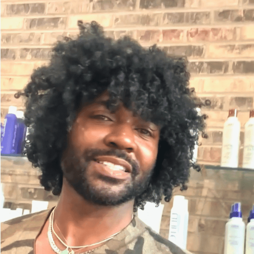 Portrait of John Hanks, a professional stylist at Q Salon & Spa, showcasing their expertise and style.